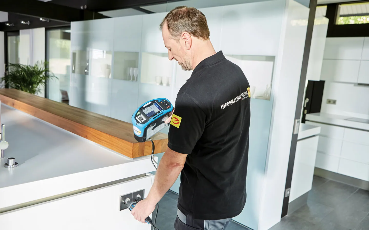 E-CHECK - Mitarbeiter prüft die Steckdosen in der Küche &middot; Winter Elektro